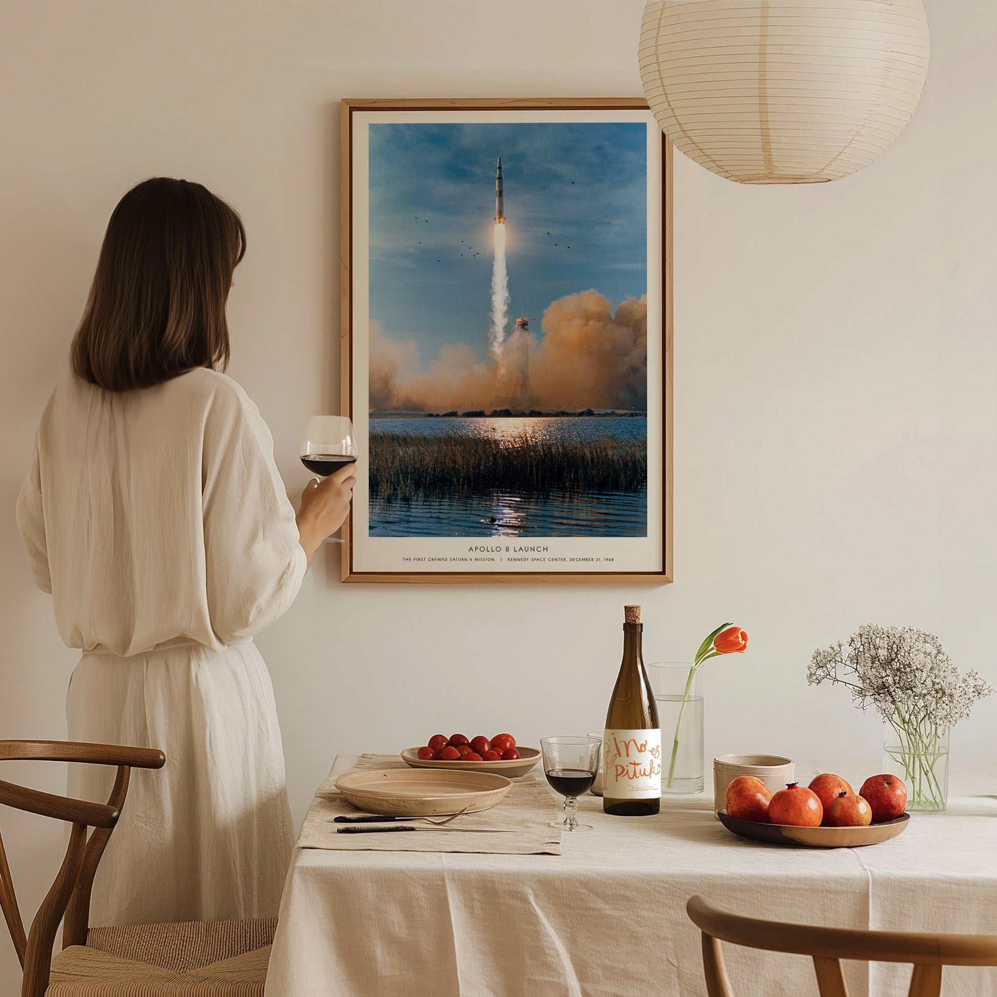 Large format Apollo 8 launch poster centered above a sofa with soft natural lighting