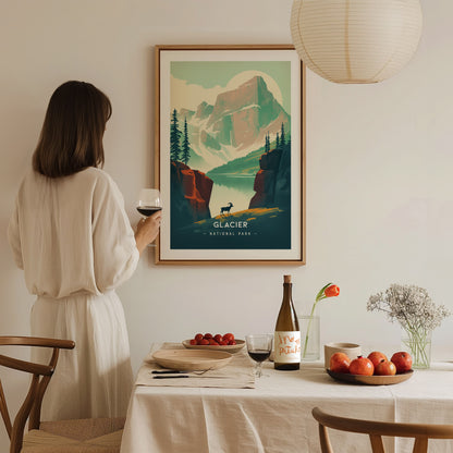 A woman in a white dress holds a glass of wine, admiring a Glacier National Park poster. A dining table with fruit, wine, and flowers is in the foreground.